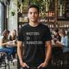 Man wearing a black t-shirt with 'WRITING IS REWRITING' text in a cafe setting.