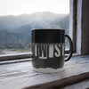 Color morphing black mug with 'TWIST' branding on a wooden surface with a mountain view in the background
