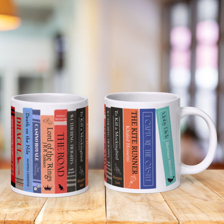 Two mugs with book spine designs on a wooden surface.