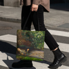 A person walking across a city crosswalk carrying a tote bag printed with a classical painting scene of a child in a garden. The person is wearing a brown shirt, black pants, and black boots.