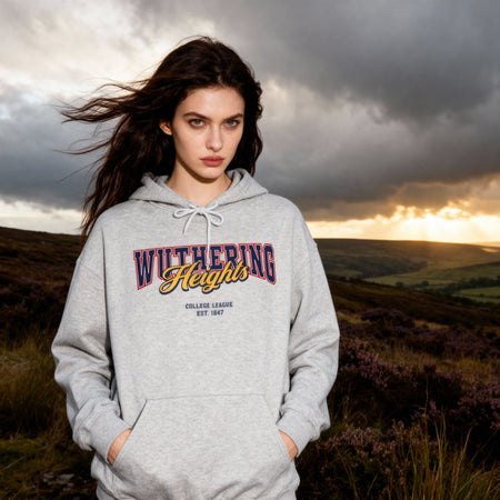 Woman wearing a 'Wuthering Heights' hoodie in a scenic outdoor setting with a dramatic sky.