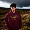 Person wearing a maroon hoodie with 'Wuthering Heights' text in a landscape