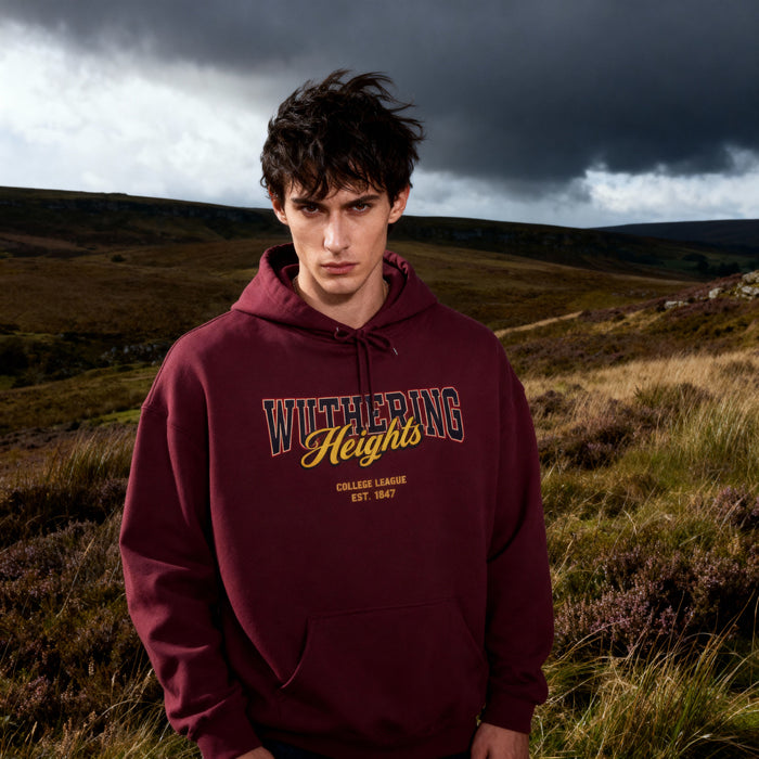 Person wearing a maroon hoodie with 'Wuthering Heights' text in a landscape