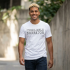 Man wearing a white t-shirt with 'UNRELIABLE NARRATOR' text, standing outdoors.